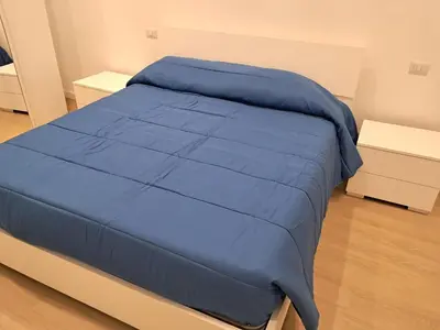 a bed with a blue comforter in a bedroom at Pigneto New collection 3 Perugia in Rome