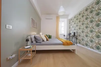 a bedroom with a bed and a wall at Circo Massimo House by Luxury Getaways in Rome
