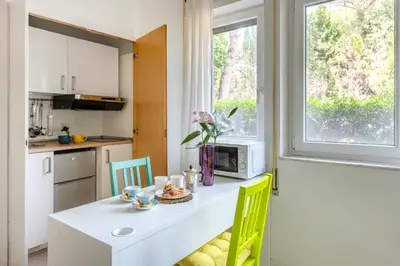 a kitchen with a table with chairs and a microwave at Aurelia vetus apartment Rome in Rome