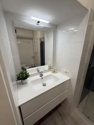 a white bathroom with a sink and a mirror at Nest Love collazia Roma 1500 mt dal Colosseo in Rome