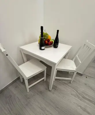 a white table with two chairs and a bowl of fruit at Nest Love collazia Roma 1500 mt dal Colosseo in Rome