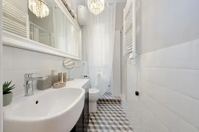 a white bathroom with a sink and a toilet at Domus al Colosseo by Luxury Getaways in Rome