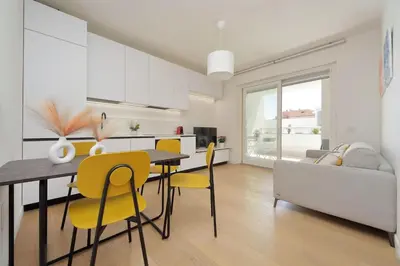 a living room with a dining table and yellow chairs at Contemporary Apartment by Luxury Getaways in Rome