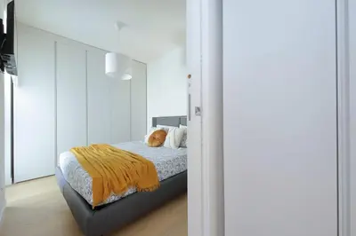 a bedroom with a bed with an orange blanket at Contemporary Apartment by Luxury Getaways in Rome