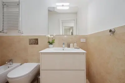 a bathroom with a sink and a toilet and a mirror at Contemporary Apartment by Luxury Getaways in Rome