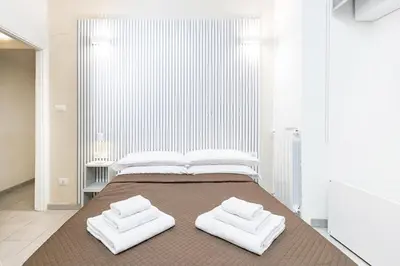 a bedroom with a large bed with two white towels at Rome Capital Apartments in Rome