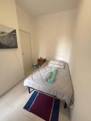 a small bedroom with a bed and a rug at Testaccio Immobiliare in Rome