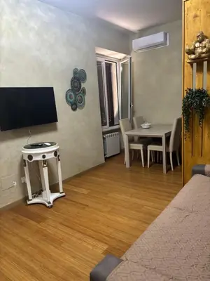 a living room with a table and a tv on the wall at Locanda di Trastevere in Rome