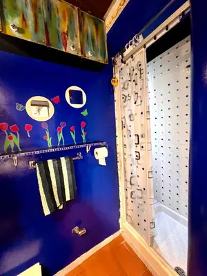 a bathroom with a blue wall with a shower curtain at Un cuore nella città eterna in Rome