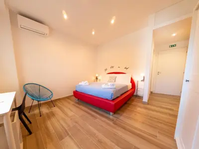 a bedroom with a red bed and a chair at New Cozy APT, close to Downtown in Rome