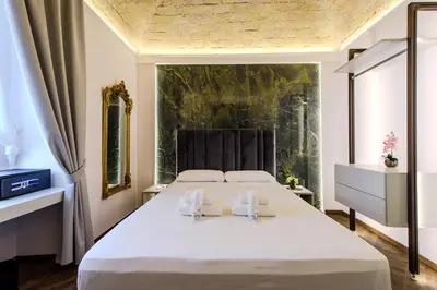 a bedroom with a large white bed with two towels at Antinous Suites in Rome