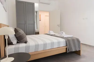a bedroom with a bed with striped sheets and a lamp at Casa Buon Vento - relax a Villa Ada in Rome