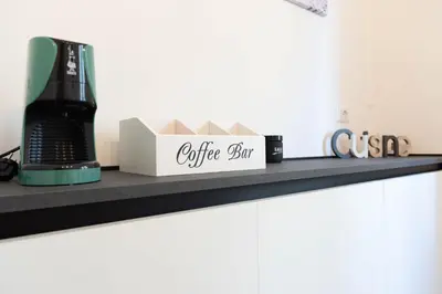 a shelf with a coffee set and a coffeemaker at Casa Buon Vento - relax a Villa Ada in Rome