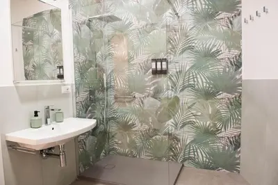 a bathroom with a green and white palm tree wallpaper at Casa Buon Vento - relax a Villa Ada in Rome