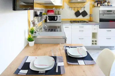 a kitchen with a table with plates on it at Wanderlust RHome - Scopri Roma e sogna il mondo! in Rome