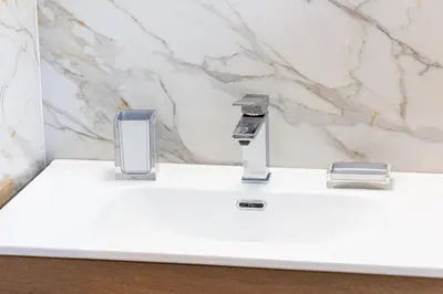 a bathroom counter with a faucet and two glasses at Luxury Rooms near St Peter in Rome