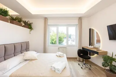 a white bedroom with a large bed and a desk at Luxury Rooms near St Peter in Rome