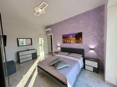 a bedroom with a large bed with a purple wall at The King's house - Rome in Rome