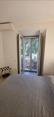 a bedroom with a bed and a large window at Al pozzo di Garibaldi in Rome