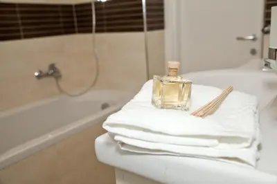 a bottle of perfume sitting on a pile of towels in a bathroom at Spanish Steps House Vittoria in Rome