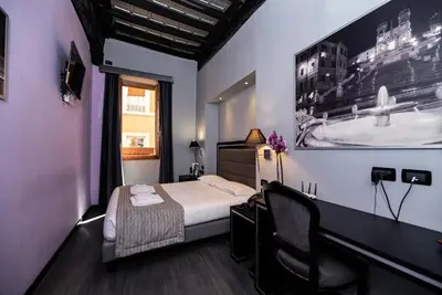 a hotel room with a bed and a desk and chairs at Imperium Suite Navona in Rome