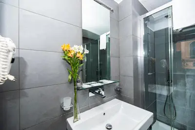 a bathroom with a sink and a vase of flowers at Imperium Suite Navona in Rome