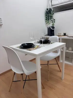 a white table with two chairs and wine glasses at Golden Suite - un piccolo loft nel cuore di Roma in Rome