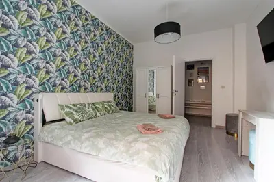 a bedroom with a bed with a tropical wallpaper at Porta Portese Luxury Suites in Rome