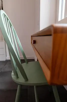 a green chair sitting next to a wooden desk at Flora Guest House in Rome