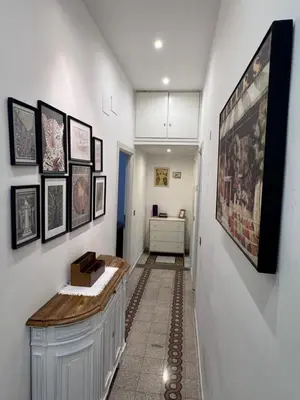 a hallway with a white wall with pictures on it at Appartamento a Roma vicino Metro Vittorio Emanuele in Rome