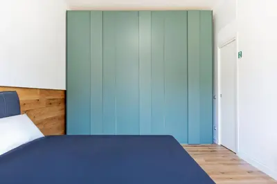a bedroom with a bed with blue walls at Luciano Boutique Apartment in Rome