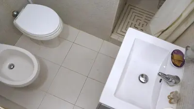 a white bathroom with a toilet and a sink at Navona Apartment in Rome