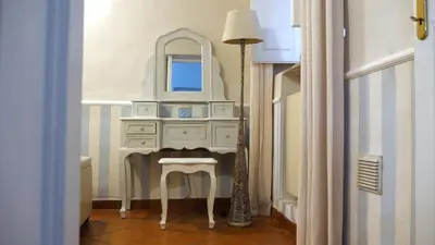 a dressing table with a mirror and a lamp in a hallway at Navona Apartment in Rome