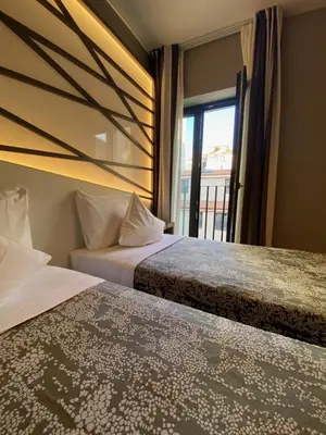 two beds in a hotel room with a window at Fortyfive Squared Hotel in Rome