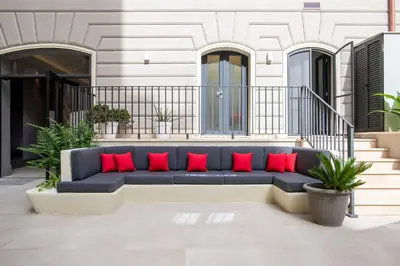 a blue couch with red pillows on a patio at Fortyfive Squared Hotel in Rome