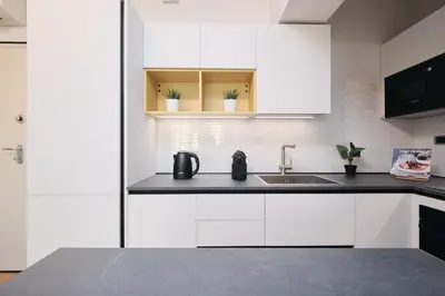 a kitchen with white cabinets and a sink at Trastevere-Colosseo, Elegant Apartment Wi-Fi & A-C in Rome