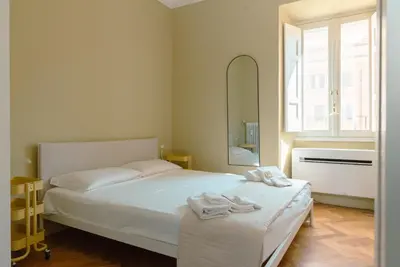 a bedroom with a white bed and a mirror at Tiber Luxury Apartment in Rome