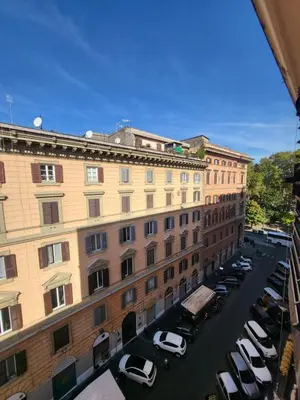 a large building with cars parked in a parking lot at Dimora Armanda Roma in Rome