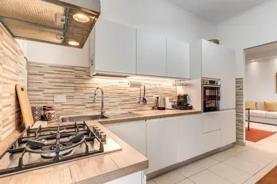a kitchen with white cabinets and a stove top oven at Maison Sofia in Rome