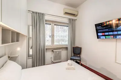 a bedroom with a bed and a tv and a chair at Maison Sofia in Rome