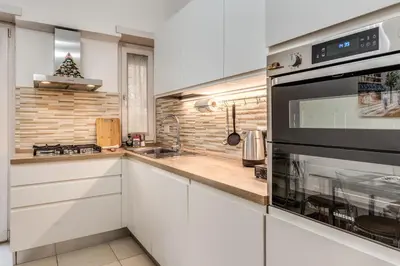 a kitchen with white cabinets and a stove top oven at Maison Sofia in Rome