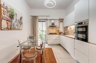 a kitchen with a glass table and chairs at Maison Sofia in Rome