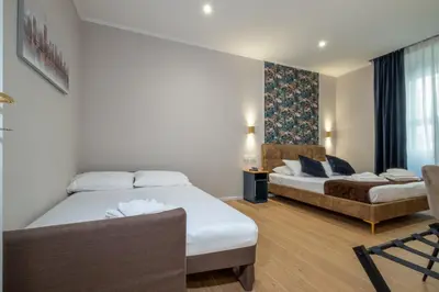 a hotel room with two beds and a chair at The Suitest Roma Apartment Appio Latino in Rome