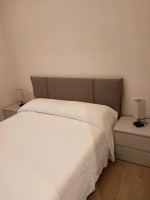 a bedroom with a white bed and two night stands at Igg VATICAN HOLIDAY in Rome