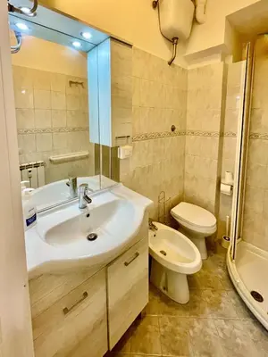 a bathroom with a sink and a toilet and a mirror at San Lorenzo vivace e giovanile in Rome
