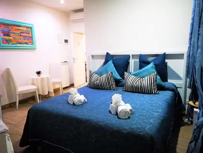 a bedroom with a blue bed with towels on it at Have A Nice Holiday - Luxury Rooms in Rome