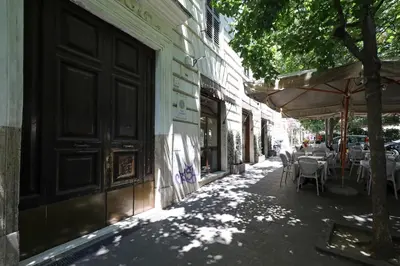 an alley with tables and an umbrella on a street at 23 FREE ROME Trastevere in Rome