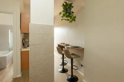 a small kitchen with a table and two stools at LA PETITE MAISON a ROME in Rome