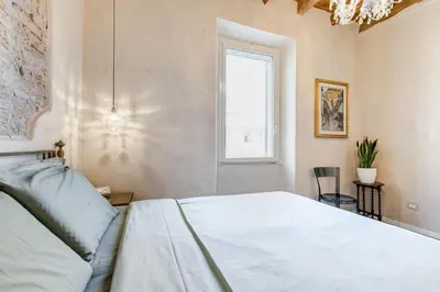 a bedroom with a large white bed and a window at Mazza Stay in Rome