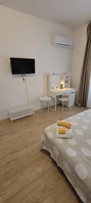 a white room with a bed and a flat screen tv at Fontana di Trevi Apartment, 24h check-in in Rome